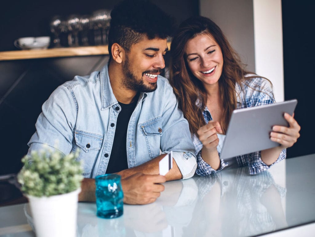 Couple sitting at table on the computer