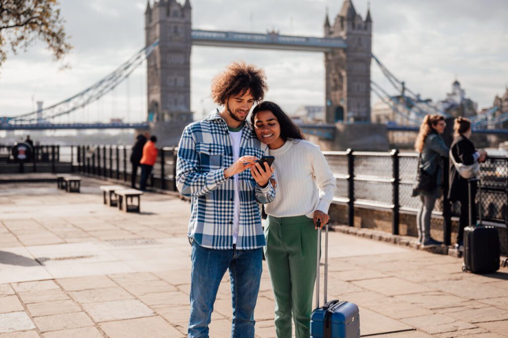 Happy traveling couple looking at smartphone