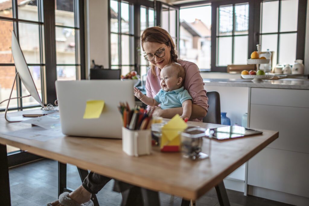 Mother with her baby boy working from home