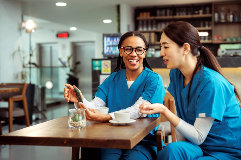 Medical workers using smart phone while having break at cafeteria