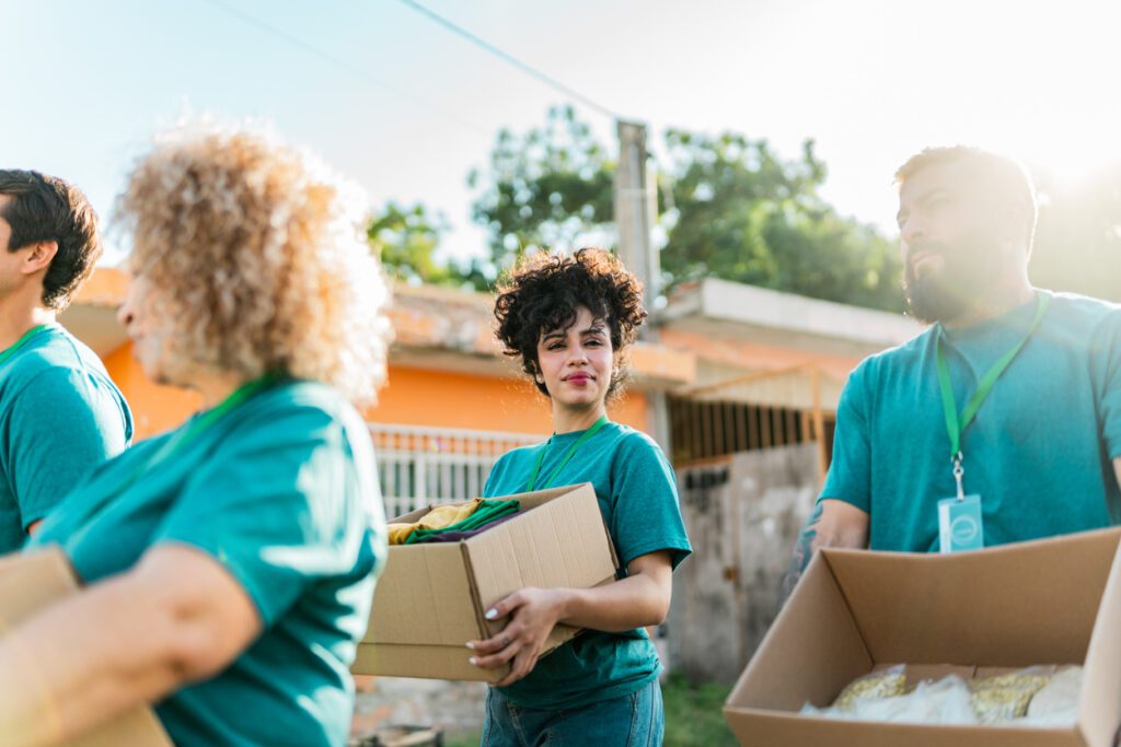 Volunteers talking and walking with donation boxes outdoors