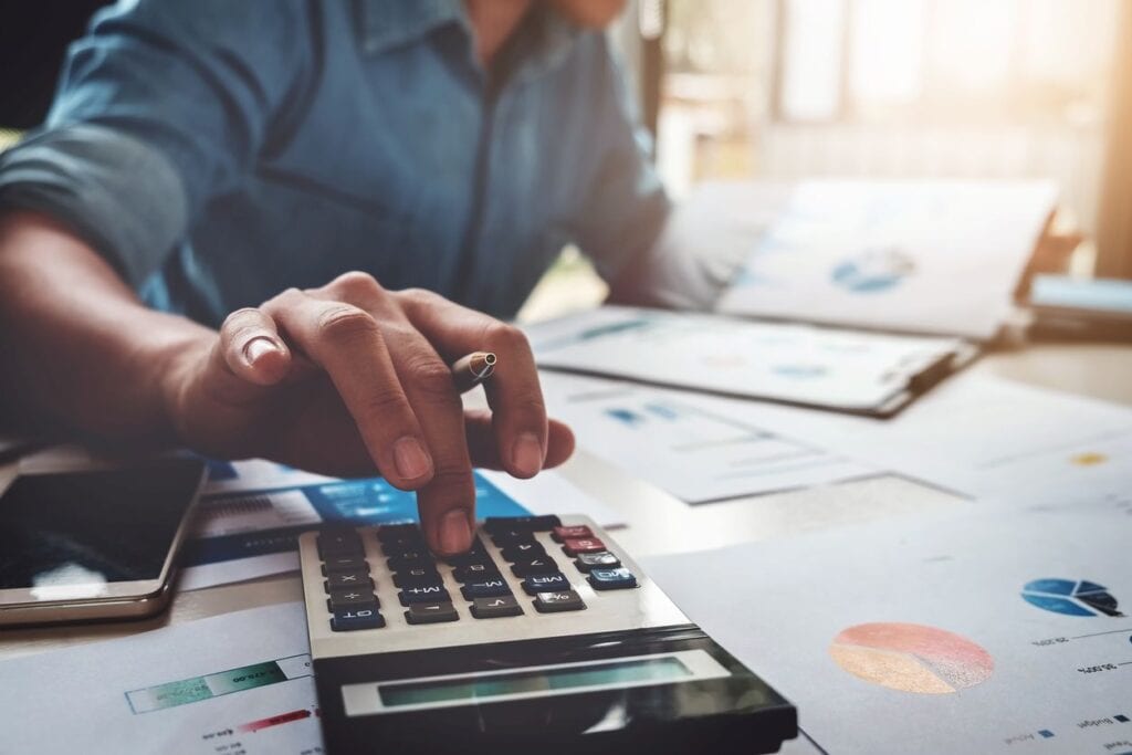 Man calculating student loan tax deductions and write-offs