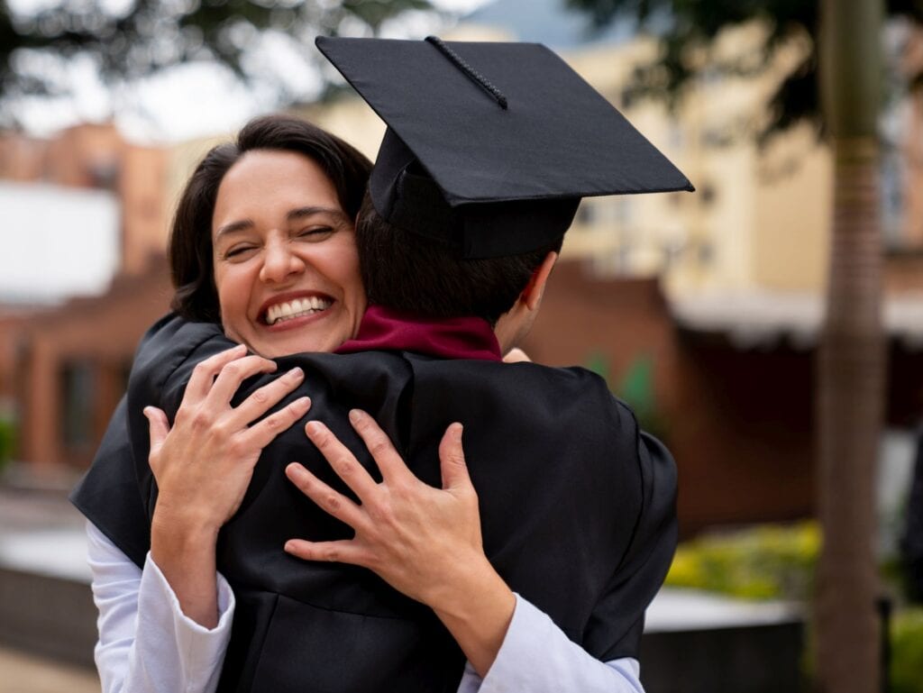 Parent hugging son at college graduation