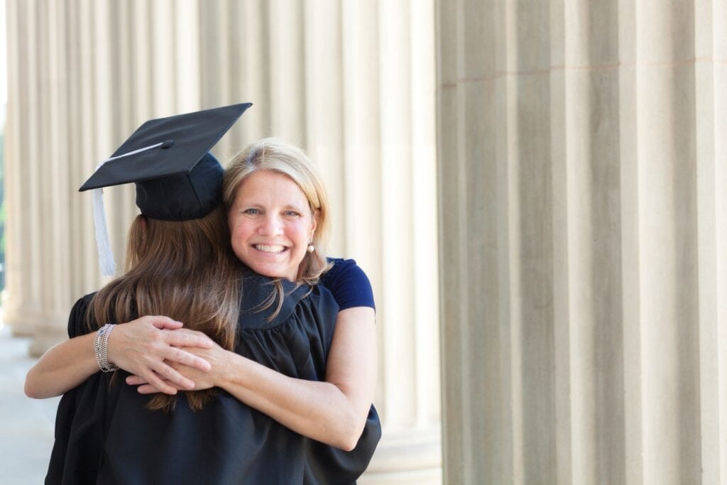 Parent with PLUS Loans hugging her graduate