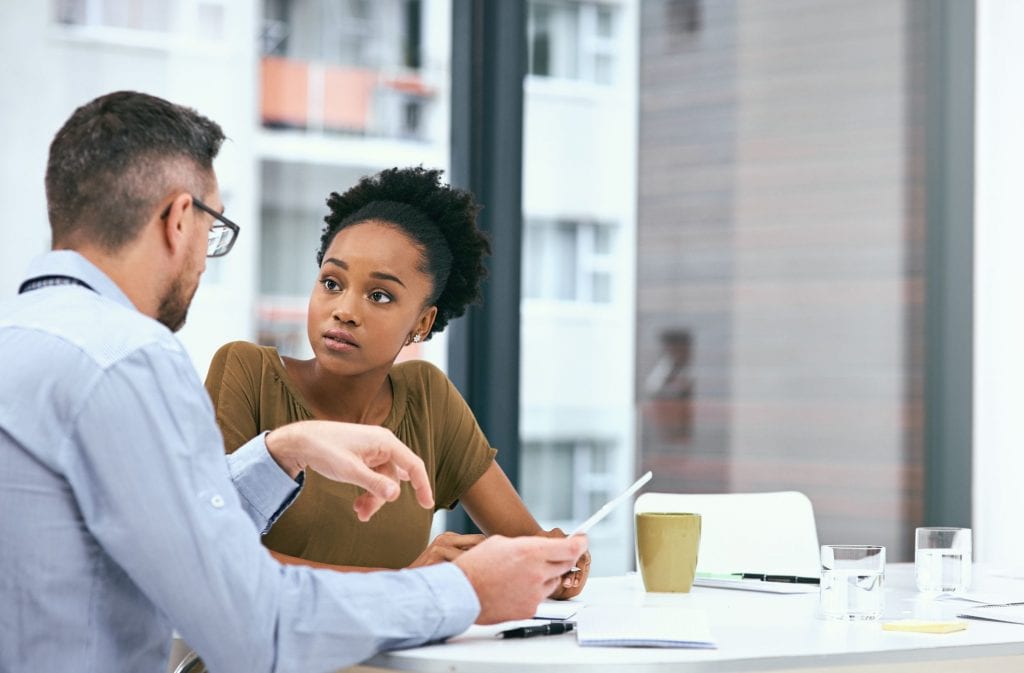 Two colleagues working together weighing the pros and cons