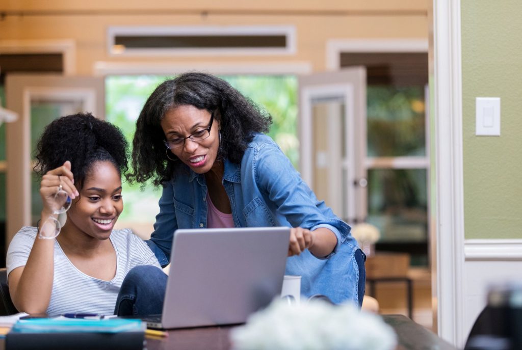 Mom and daughter reading private and federal student loan eligibility requirements