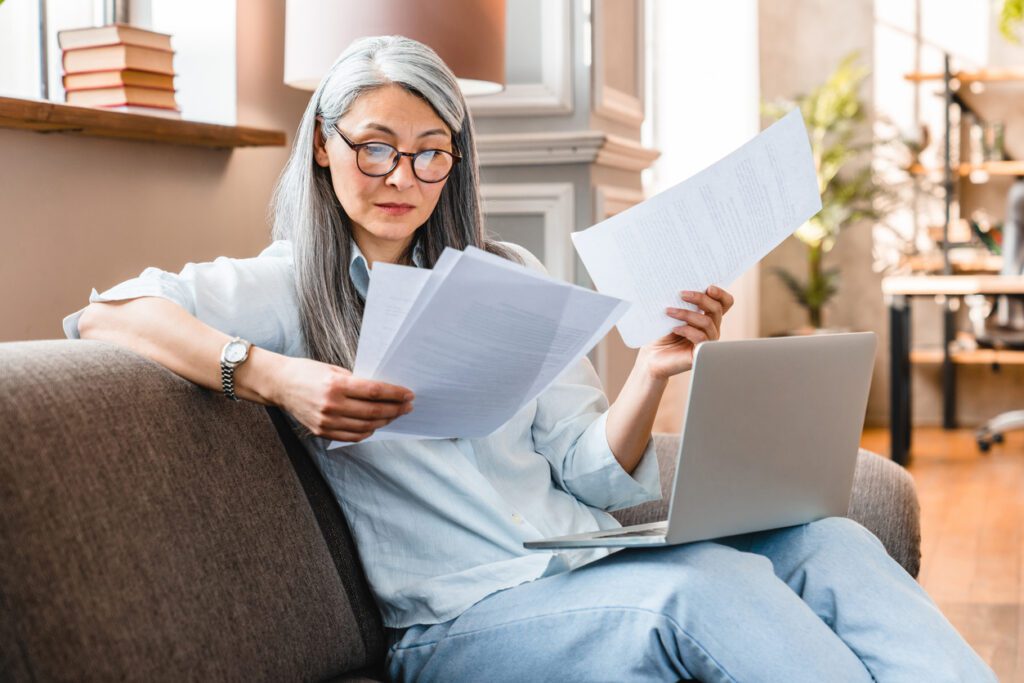 Busy attractive mature businesswoman working at home with laptop