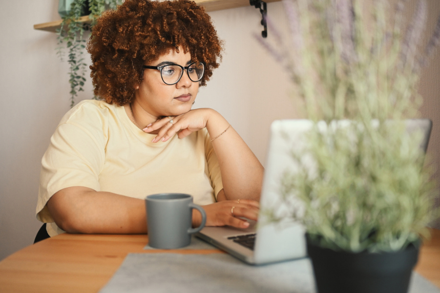 Young black woman looking at her laptop.