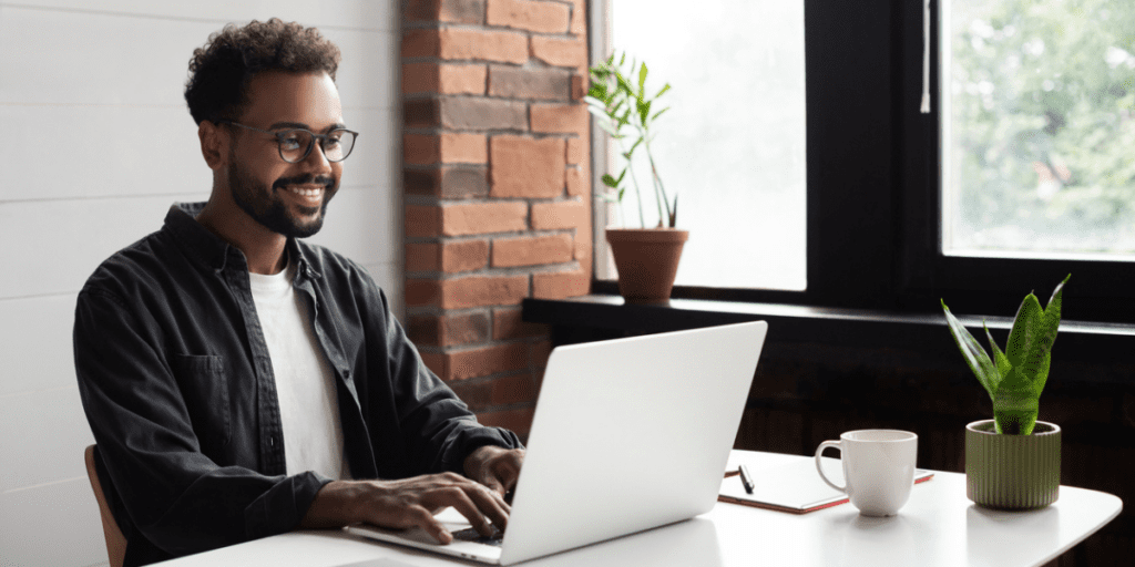 Black man sitting at his desk on computer.