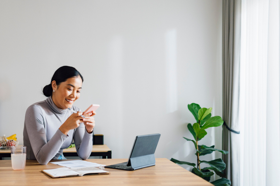 Young Asian woman looking at her credit score on her phone.