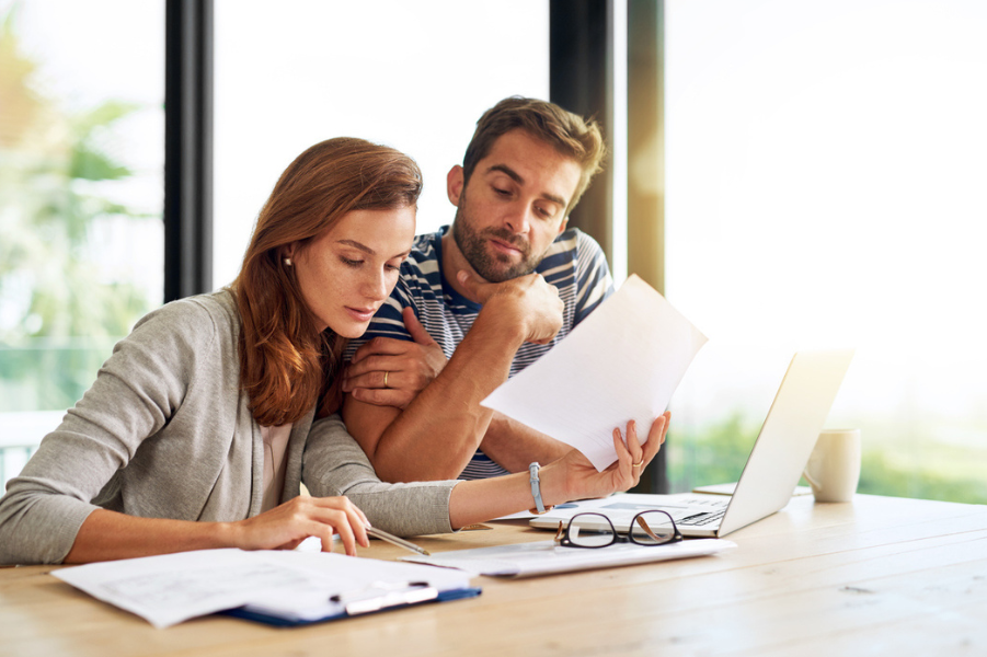 Married couple looking over student loan paperwork.