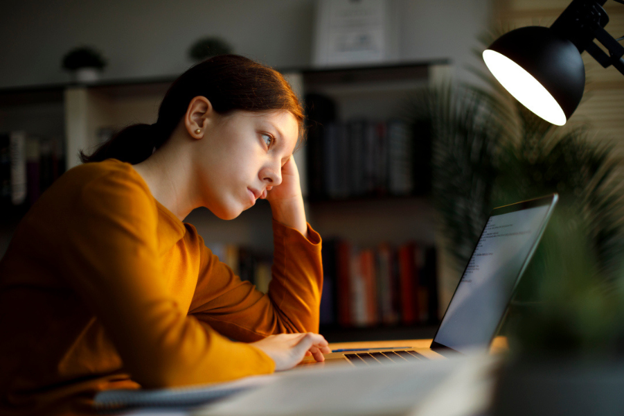 Financially stressed college student sits at her desk.