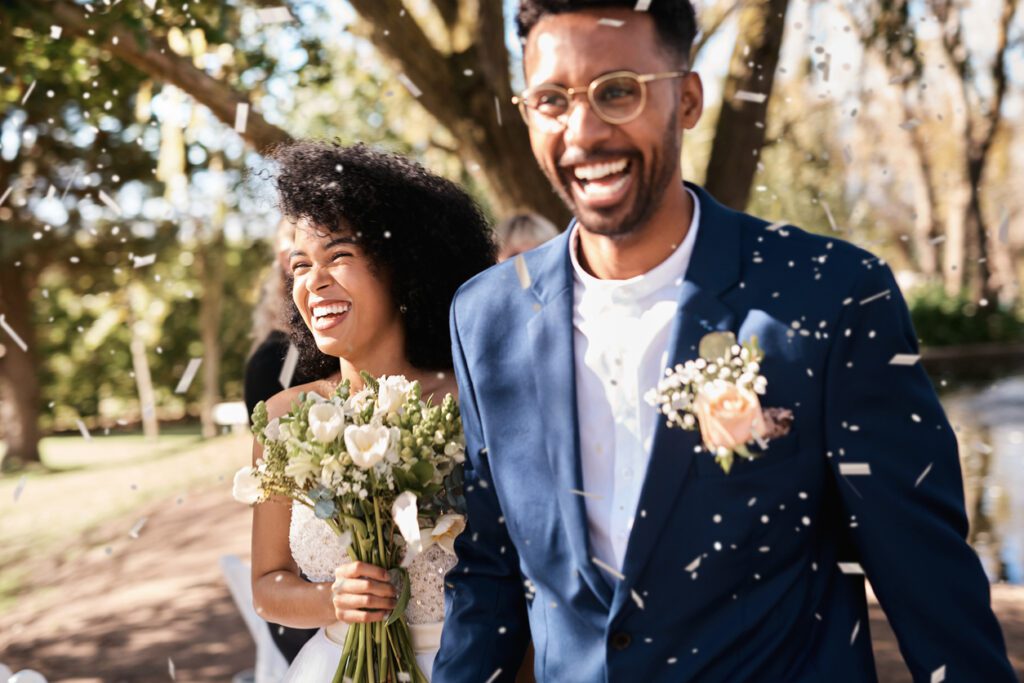 Shot of a happy newlywed young couple getting showered with confetti outdoors on their wedding day