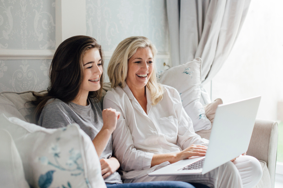 Mother and daughter looking at parent plus loan refinancing options on the computer