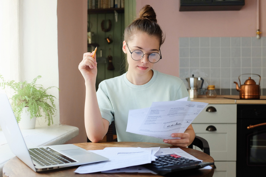 Young female student looking over tax paperwork.