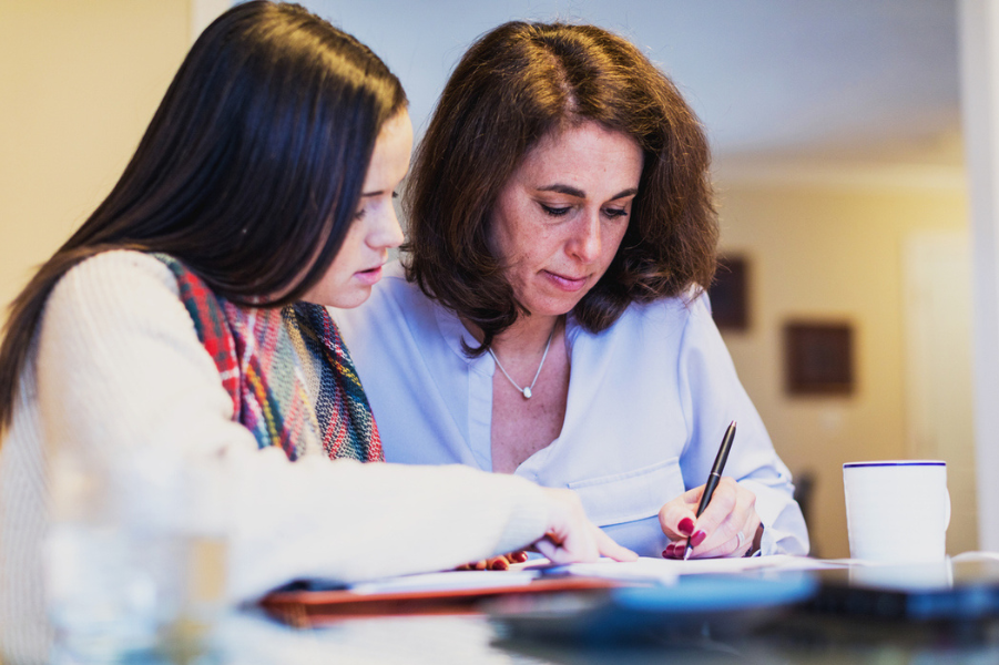 Mother and daughter looking over refinancing student loan with cosigner.