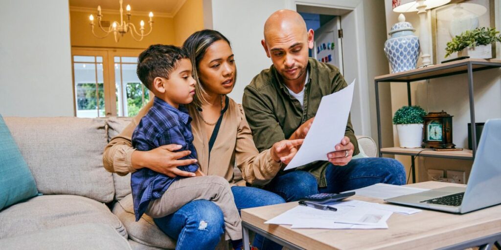 Young parents with son looking over budget to see how much to save for college.