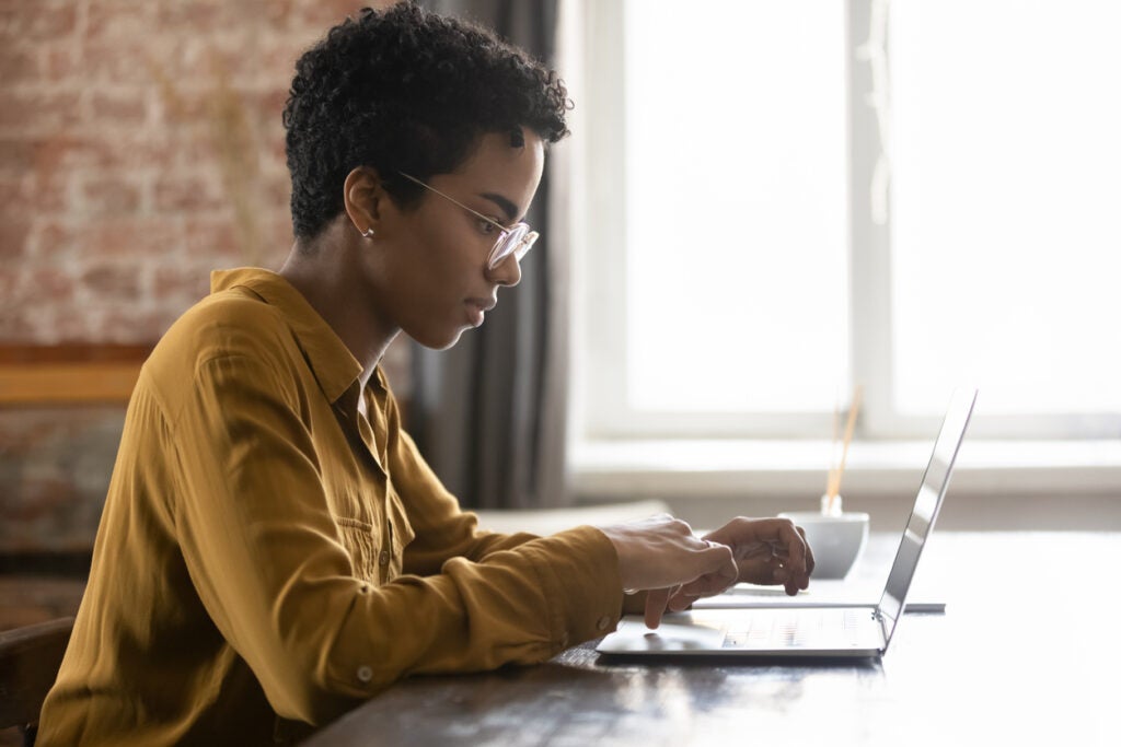 Female student researching the Save for a valuable education plan on their laptop.