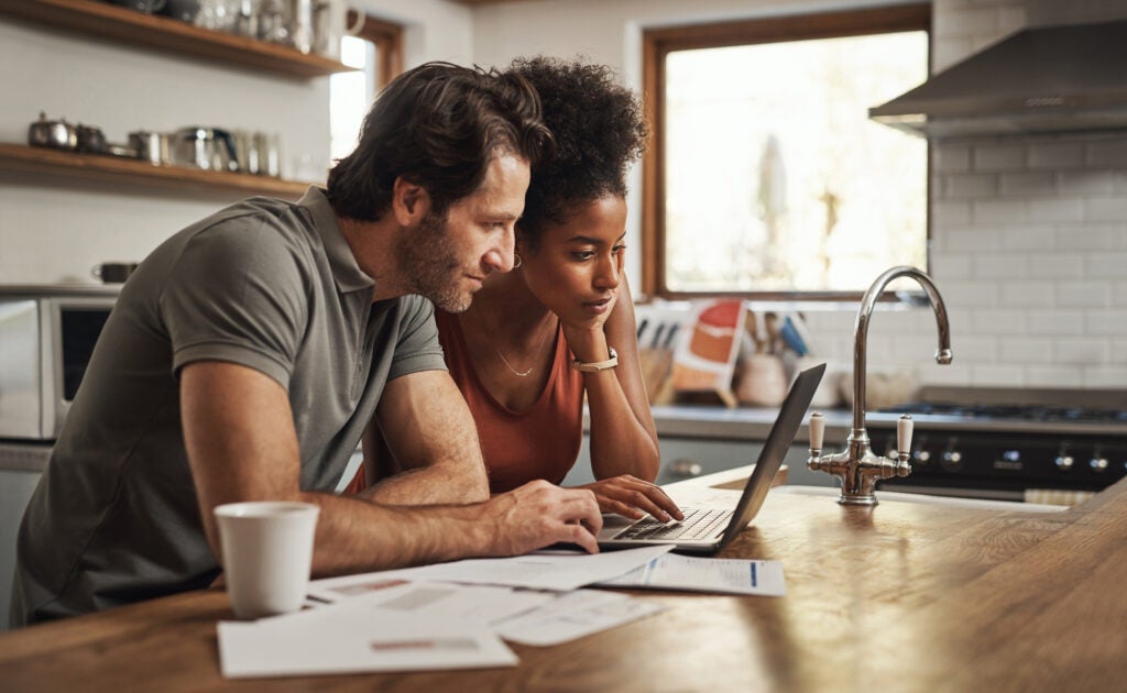 Young couple looking over student loan debt before marriage.