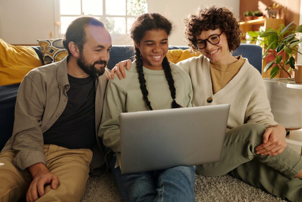 Parents and child looking at the FAFSA changes on a laptop at home.