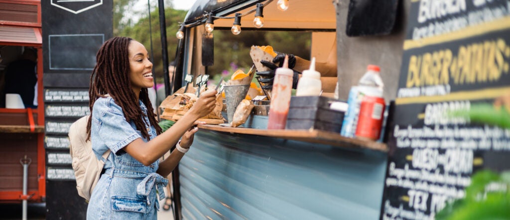 Young woman purchasing from a food truck with a card