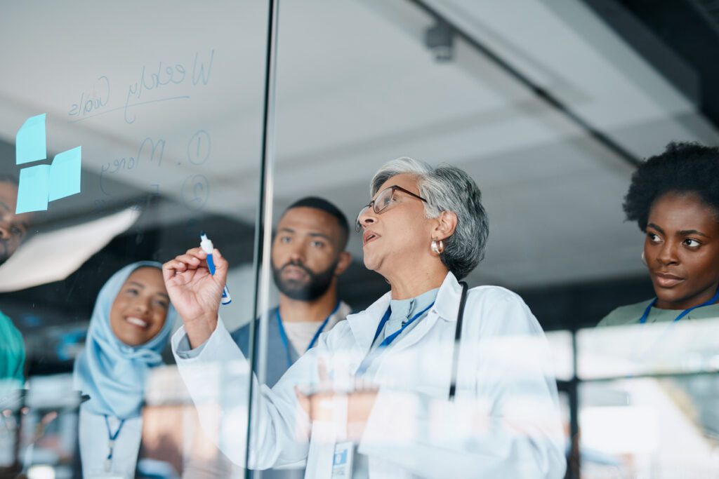 Healthcare, glass and woman writing, staff and brainstorming for procedure, diagnosis and research. Medical professionals, leader and teamwork to share ideas, medicine development and conversation