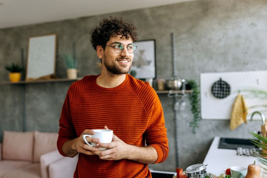 Young man enjoying a cup of coffee in his domestic kitchen